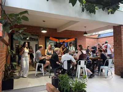 a group of people sitting at tables in a restaurant at Black Sheep Medellin in Medellín