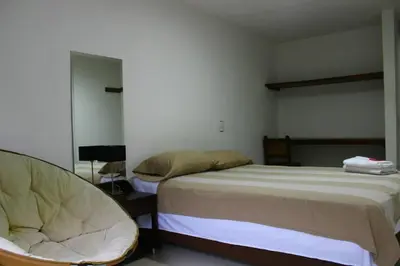 a bedroom with a bed and a chair in it at Black Sheep Medellin in Medellín
