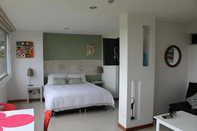a bedroom with a white bed and a couch at LLanogrande Aparta Estudio Puerto Bulevar in Rionegro