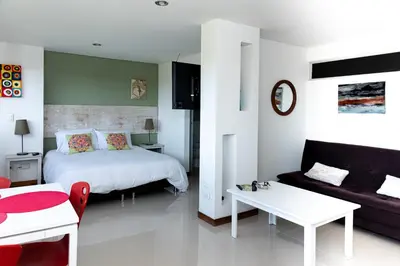 a bedroom with a bed and a couch and a table at LLanogrande Aparta Estudio Puerto Bulevar in Rionegro