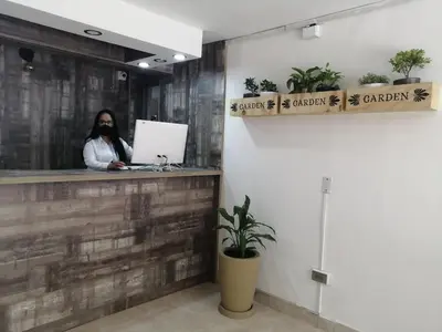a woman is sitting at a counter with a computer at Hotel Sol del Estadio in Medellín