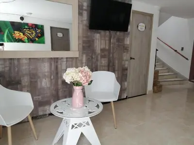 a vase of flowers on a table in a living room at Hotel Sol del Estadio in Medellín