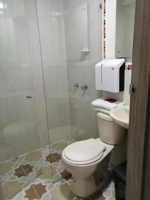 a bathroom with a toilet and a shower and a sink at Hotel Sol del Estadio in Medellín