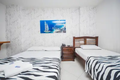 two beds sitting next to each other in a room at Hotel Estadio Real in Medellín