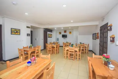 a dining room with wooden tables and chairs at Hotel Estadio Real in Medellín