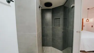 a bathroom with a shower with a glass door at Hotel Balcones del Estadio in Medellín