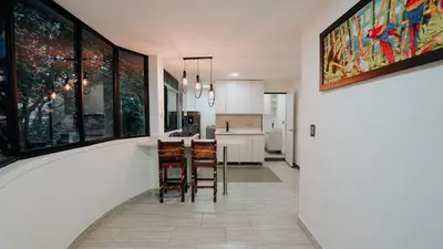 a kitchen and dining room with a table and chairs at Hotel Balcones del Estadio in Medellín