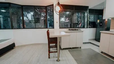a kitchen with a table and some windows at Hotel Balcones del Estadio in Medellín