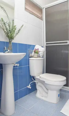 a bathroom with a toilet and a sink at Hotel Alcazar in Medellín