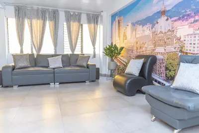 a living room with a couch and two chairs at Hotel Alcazar in Medellín
