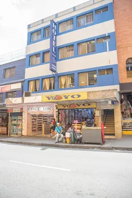 a building on the side of a street with a store at Hotel Alcazar in Medellín