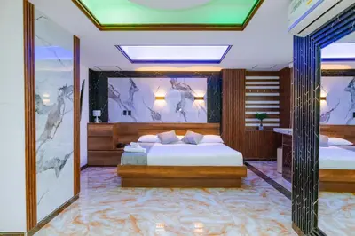 a bedroom with two beds and a painting on the wall at Hotel Shaira 2 in Quibdó