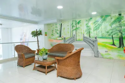 a lobby with wicker chairs and a mural at Hotel Shaira 2 in Quibdó