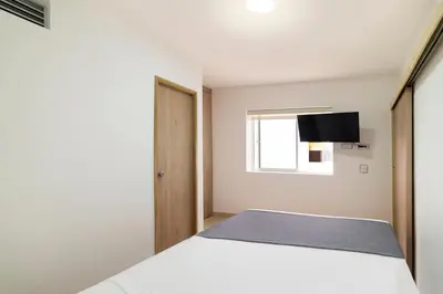 a bedroom with a white bed and a window at Ayenda Casa Megua in Medellín