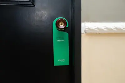 a door with a green door tag on it at Ayenda Casa Megua in Medellín