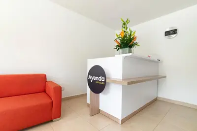 a waiting room with a red chair and a sign at Ayenda Casa Megua in Medellín