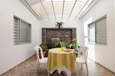 a dining room with a table and chairs and a fireplace at Ayenda Casa Megua in Medellín