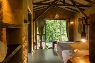 a bedroom with a bed and a large window at Cabañas en la montaña Viga Vieja in San Peregrino
