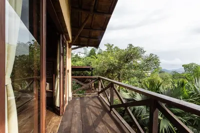 a balcony of a house with a view of the forest at Cabañas en la montaña Viga Vieja in San Peregrino