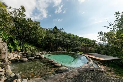 a swimming pool in a garden with rocks and a bench at Cabañas en la montaña Viga Vieja in San Peregrino