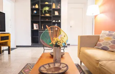 a living room with a couch and a table with flowers at Africa house-Casa Hotel Laureles-La70 in Medellín