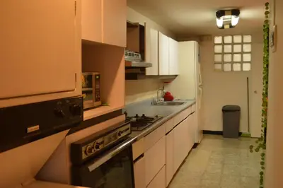 a kitchen with white cabinets and a stove top oven at Africa house-Casa Hotel Laureles-La70 in Medellín