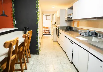 a kitchen with white cabinets and a table and chairs at Africa house-Casa Hotel Laureles-La70 in Medellín