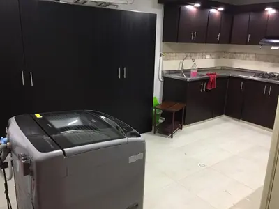 a kitchen with black cabinets and a trash can at casa hostal las palmeras in Guatapé