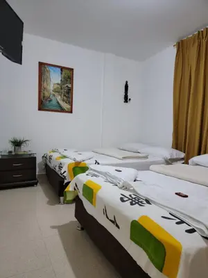 a row of beds in a room with a tv at Rosita 2 in Jardin