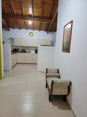 a living room with a chair and a kitchen at Rosita 2 in Jardin