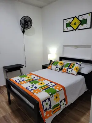 a bedroom with a bed with a comforter on it at Hotel La Posada in Belén de Umbría
