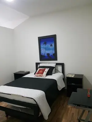 a bedroom with a bed with a picture on the wall at Hotel La Posada in Belén de Umbría