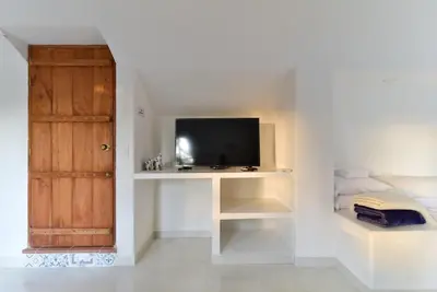 a living room with a tv and a white wall at Aldea Bella Boutique in Doradal