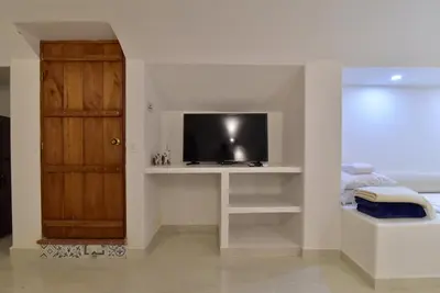 a living room with a tv on a table and a door at Aldea Bella Boutique in Doradal