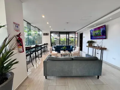 a living room with a couch and a bar at EcoHub Hotel Medellin in Medellín
