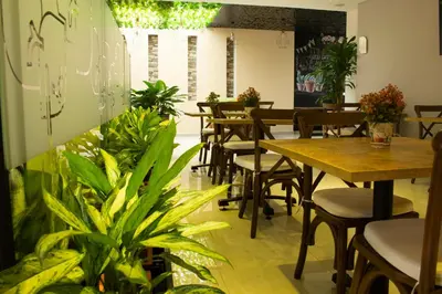 a restaurant with tables and chairs and plants at EcoHub Hotel Medellin in Medellín