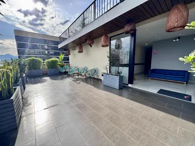 a balcony of a building with chairs and a staircase at EcoHub Hotel Medellin in Medellín