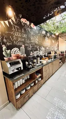 a restaurant with a wall with writing on it at EcoHub Hotel Medellin in Medellín