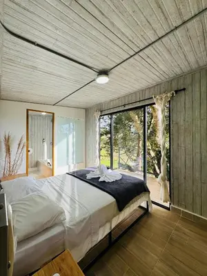 a bedroom with a large bed and a large window at La Madriguera in Guatapé