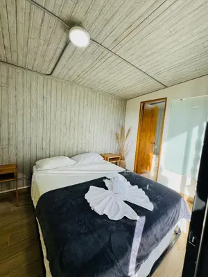 a bedroom with a bed with two white flowers on it at La Madriguera in Guatapé