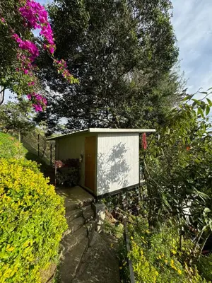 a small building in a garden with flowers at La Madriguera in Guatapé