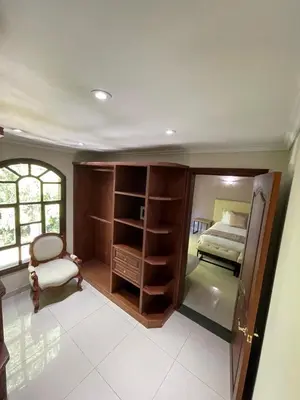 a room with a bedroom with a bed and a chair at Villa de los Angeles in Medellín