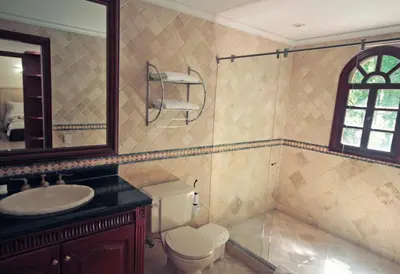 a bathroom with a toilet and a sink and a mirror at Villa de los Angeles in Medellín