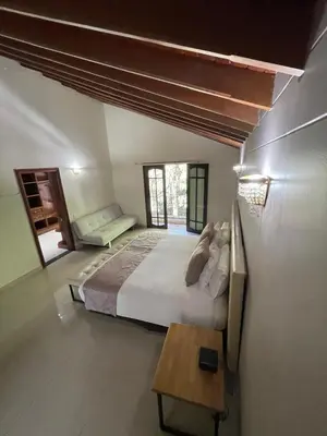 a bedroom with a large bed and a table at Villa de los Angeles in Medellín