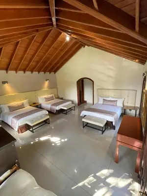 a large room with two beds and a table at Villa de los Angeles in Medellín