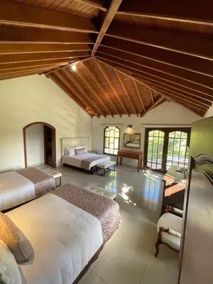 a large bedroom with two beds and a desk at Villa de los Angeles in Medellín