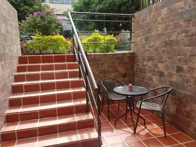 a patio with a table and chairs and stairs at ApartaStudio Calasanz- Cerca Estación Metro Floresta in Medellín