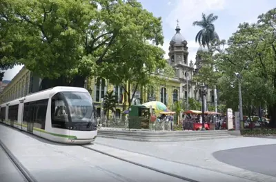 a white train on a city street with a building at ApartaStudio Calasanz- Cerca Estación Metro Floresta in Medellín
