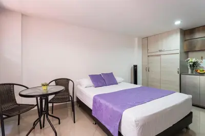 a bedroom with a bed and a table and chairs at ApartaStudio Calasanz- Cerca Estación Metro Floresta in Medellín
