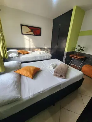 two beds in a hotel room with pillows on them at Hotel Laureles Home in Medellín